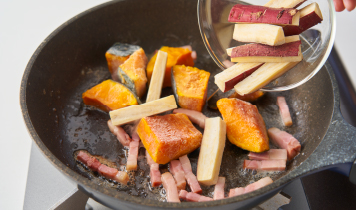 フライパンにバターを入れてベーコンを炒め、かぼちゃとさつまいもを凍ったまま加える。4分ほど炒めたらサラダチキンを手でほぐしながら入れ、グラタンソースを加える。